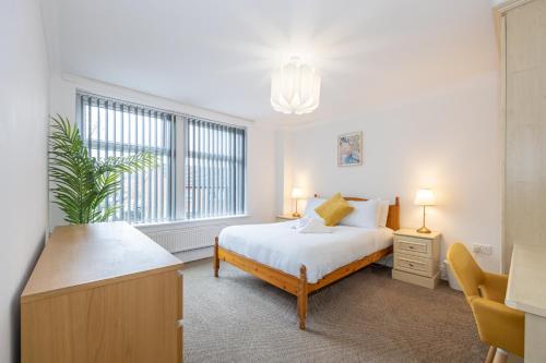 a bedroom with a bed and a large window at The Burton- Free Gated Parking in Manchester
