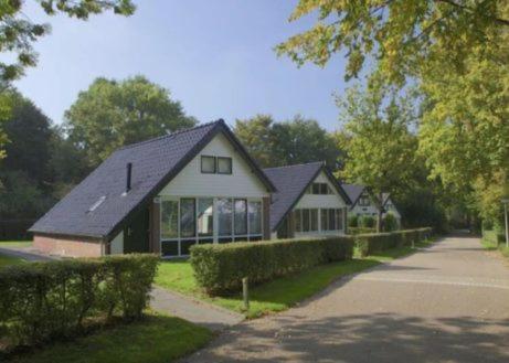 a house with a black roof on a street at Groenpark Simpelveld in Simpelveld