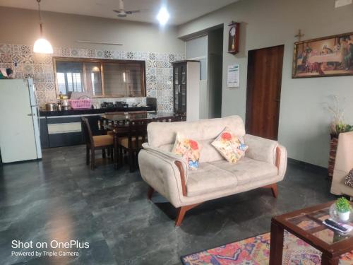 a living room with a chair and a kitchen at Eleson Cliffside Retreat in Panchgani
