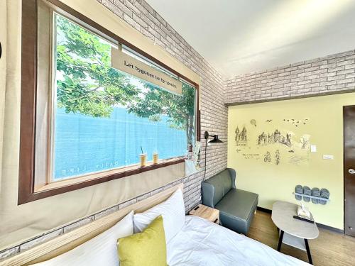 a bedroom with a large window and a bed and a chair at 一中北極熊 in Taichung