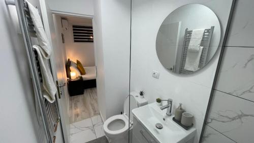 a white bathroom with a sink and a mirror at LUXURY STUDIO in Onești