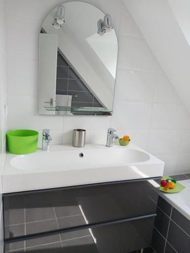 ein Badezimmer mit einem weißen Waschbecken und einem Spiegel in der Unterkunft VILLA TARA 