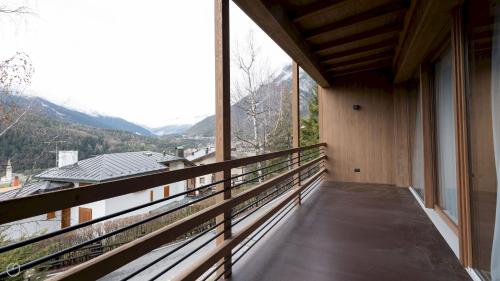 un balcone di una casa con montagne sullo sfondo di Italianway - Dosso del Grillo 1A a Valdidentro