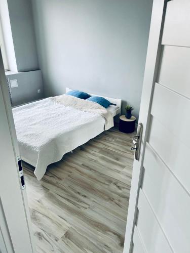 a small bedroom with a bed and a door at Apartament z sypialnią Giżycko in Giżycko