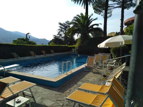 a swimming pool with chairs and an umbrella at La Ricciola - Eurotel 523 in Rapallo