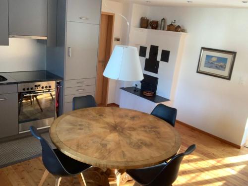 eine Küche mit einem Holztisch und Stühlen in der Unterkunft Charmantes Alpen-Appartement in Conters, Davos-Parsenn in Conters
