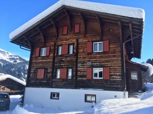 ein Blockhaus im Schnee mit Schnee in der Unterkunft Charmantes Alpen-Appartement in Conters, Davos-Parsenn in Conters