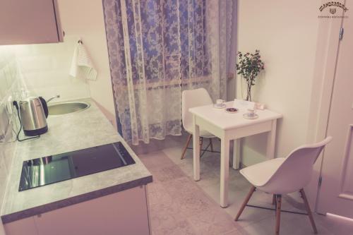a kitchen with a table and a white table and chairs at Mandragora Apartments 22 in Lublin