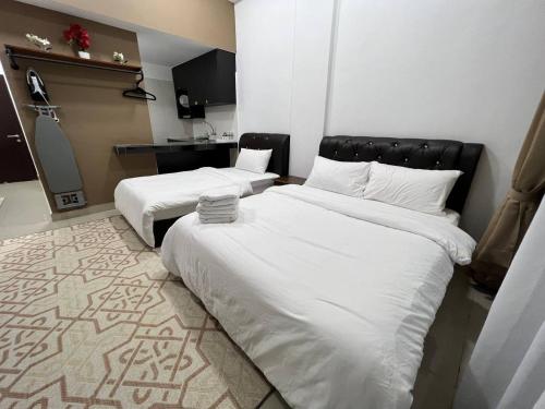 HASSMA Studio Apartment with Pool في غُوا موسانغ: سريرين في غرفة الفندق ذات شراشف بيضاء