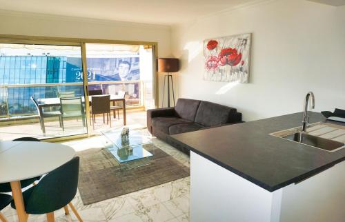 une cuisine et un salon avec un canapé et une table dans l'établissement LEM5F - Palmes d'Or Properties, à Cannes