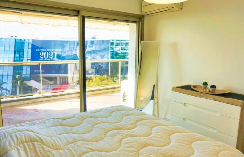 une chambre avec un lit et une grande fenêtre dans l'établissement LEM5F - Palmes d'Or Properties, à Cannes