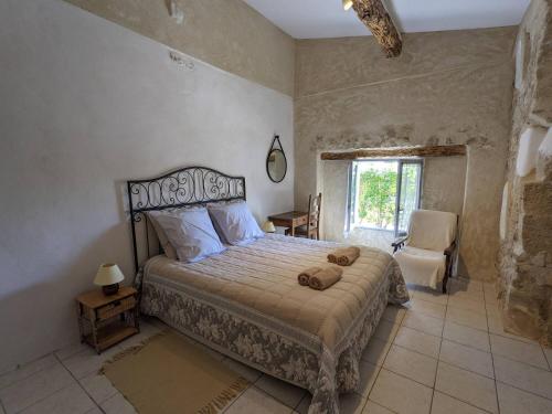 a bedroom with a bed and a chair and a window at gite ventoux in Loriol-du-Comtat