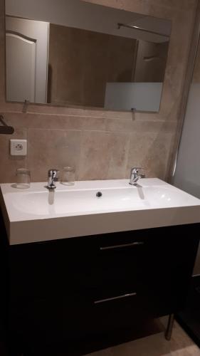 y baño con lavabo blanco y espejo. en gite ventoux en Loriol-du-Comtat