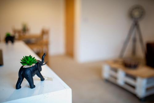 a toy elephant with a plant on its back on a table at Old Sarum House in Old Sarum