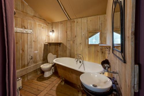 a bathroom with a tub and a toilet and a sink at Camping Le Pech Charmant in Les Eyzies-de-Tayac