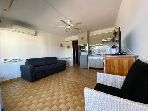 un salon avec un canapé bleu et une cuisine dans l'établissement Sol-y-Days Lagune 1, studio Port Camargue Sud accès direct aux plages, au Grau-du-Roi