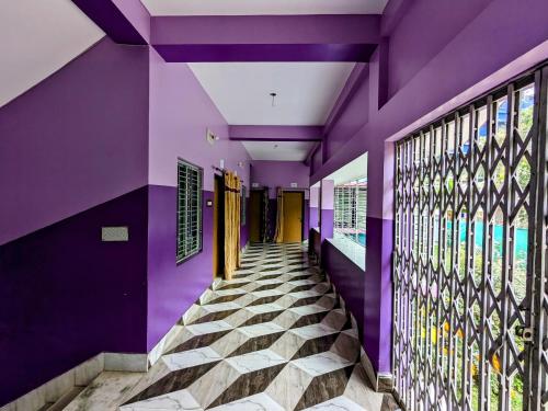 un couloir d'une maison aux murs violets dans l'établissement Sundarban Tulip Homestay, Pakhiralay, WB, à Purbbadulki