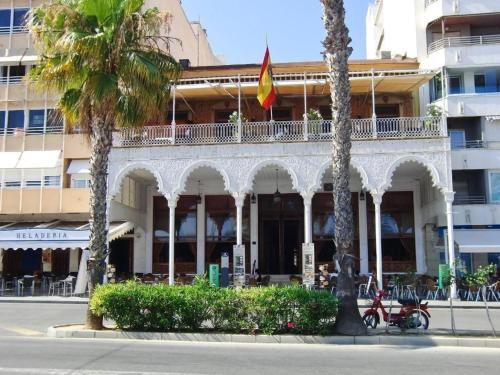 un edificio con palmeras frente a una calle en Apartamento cerca a la playa del Cura ! Cura Beach, en Torrevieja