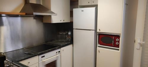 uma cozinha com armários brancos e um frigorífico branco em Habitación de matrimonio en el centro em Castellón de la Plana