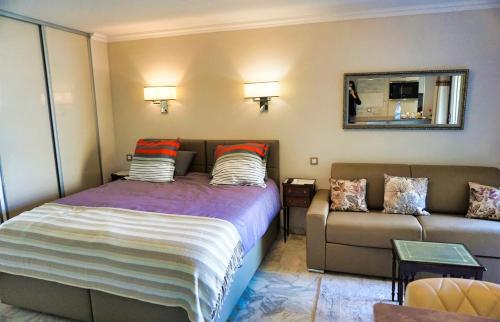 une chambre avec un lit et un canapé dans l'établissement Studio Cannes center next to Croisette and rue d'Antibes, à Cannes