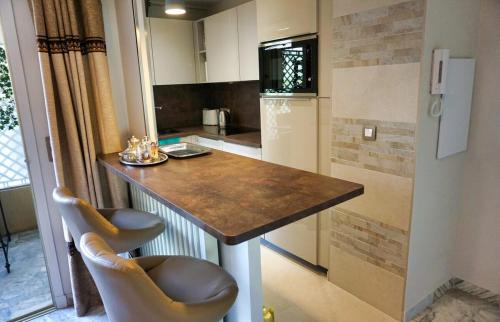 une cuisine avec un comptoir avec deux chaises et une table dans l'établissement Studio Cannes center next to Croisette and rue d'Antibes, à Cannes