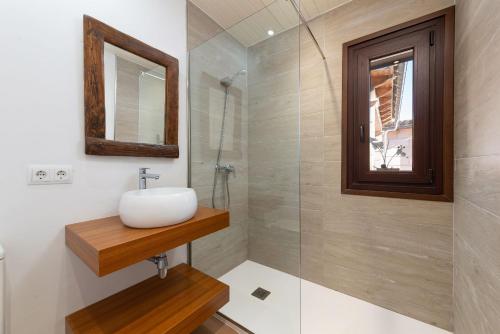 a bathroom with a sink and a glass shower at Sa Cova - Alcúdia in Alcudia