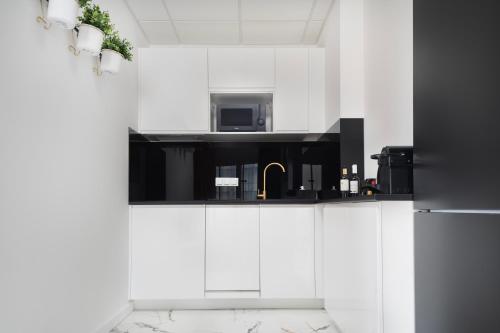 a kitchen with white cabinets and a microwave at Vola Palace in Warsaw