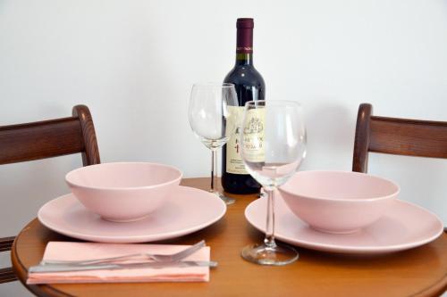 a table with two bowls and a bottle of wine at Studio Milan in Vračar (historical)