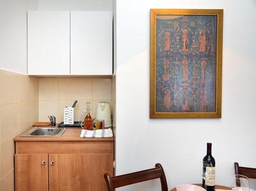 una cucina con lavandino e un dipinto sul muro di Studio Milan a Vračar (historical)