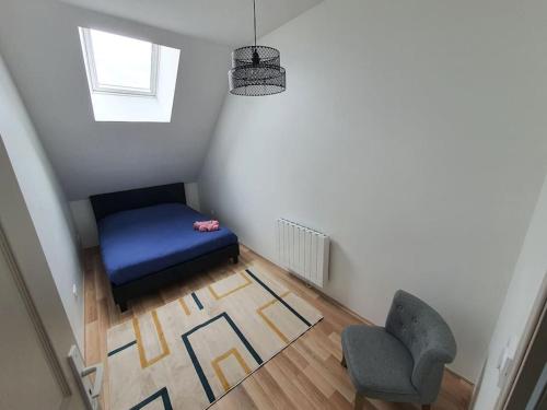 a small room with a blue ottoman and a chair at Appartement 4 personnes proche gare et hôpital in Saint-Amand-Montrond