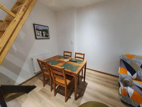 a dining room with a table and chairs and a couch at Appartement 4 personnes proche gare et hôpital in Saint-Amand-Montrond