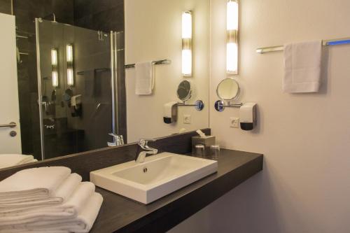 a bathroom with a sink and a mirror and towels at aparthotel Cochem in Cochem