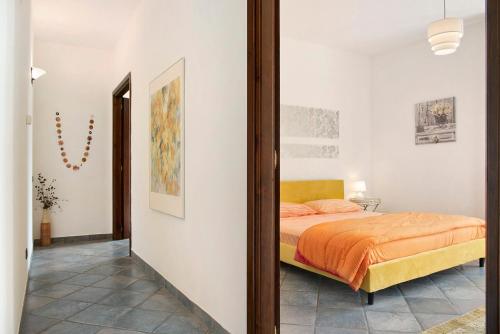 una camera con un letto e una coperta arancione di La Dolce Vita a CastellʼAlfero