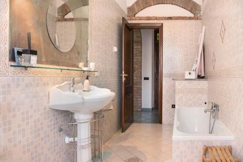 y baño con lavabo, espejo y bañera. en La Dolce Vita, en CastellʼAlfero
