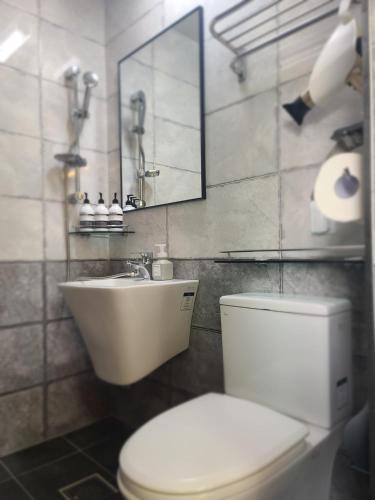 La salle de bains est pourvue de toilettes, d'un lavabo et d'un miroir. dans l'établissement TreehouseUnseo GuestHouse, à Incheon