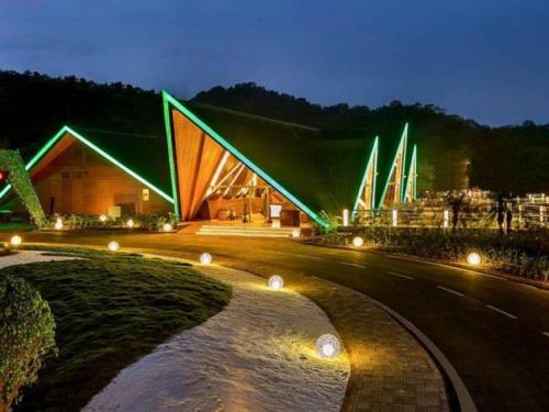 a building with green lights on it at night at Aamby Valley City in Lonavala