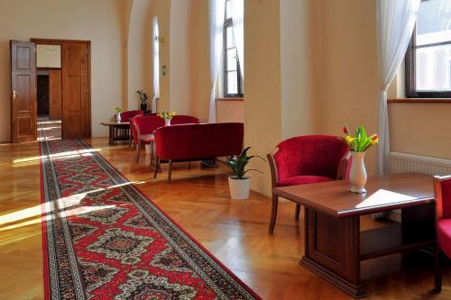 a waiting room with red chairs and a rug at Zamek Cerveny Hradek in Jirkov
