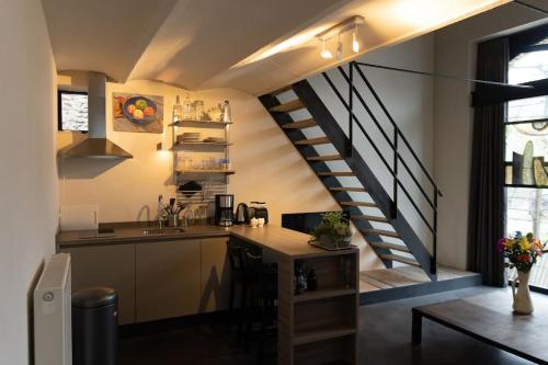 a kitchen with a table and a staircase in a room at Vakantiehuisje 't Goed Geluk in Lanaken