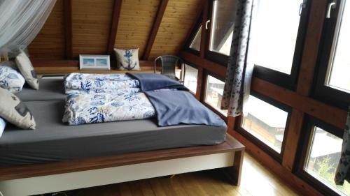 a bed sitting in a room with windows at Exklusive Ferienwohnung Lurelei 150 qm mit Traumblick 4 bis 9 P in Bacharach
