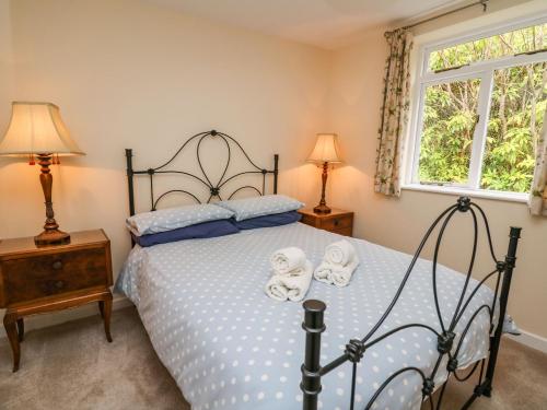 a bedroom with a bed with two towels on it at Salmon Cottage in Llanwrthwl
