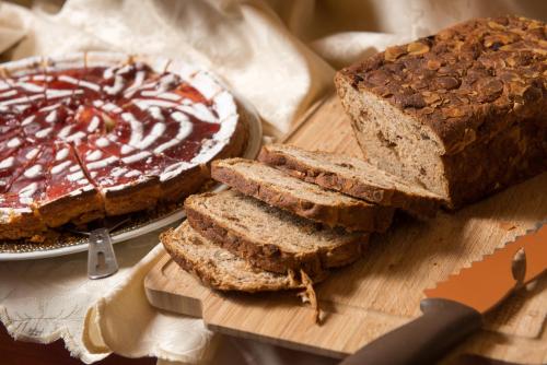 a cutting board with a loaf of bread and a cake at Hotel Berna in Milan