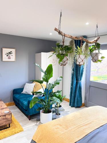 a living room with a bed and plants at Aplanty Studio in the Orchard 