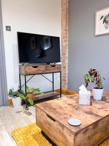 a living room with a flat screen tv on a table at Aplanty Studio in the Orchard in Walsoken
