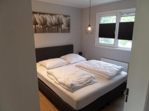 a bed with white sheets and pillows in a bedroom at Vakantiepark Camping de Peelpoort in Asten-Heusden