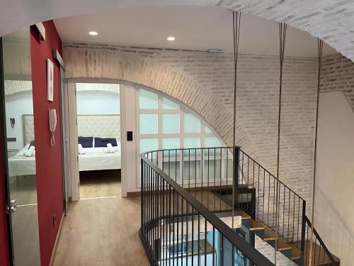 a staircase in a room with a brick wall at Apartamentos Living Sevilla Centro Maestranza in Seville