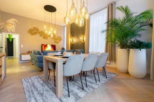 - une salle à manger et un salon avec une table et des chaises dans l'établissement The 99, Appartement sauna & parking, à Liège