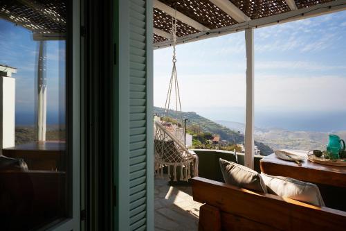 a balcony with a view of the ocean from a house at Cycladic Villa ERoza in Ioulida