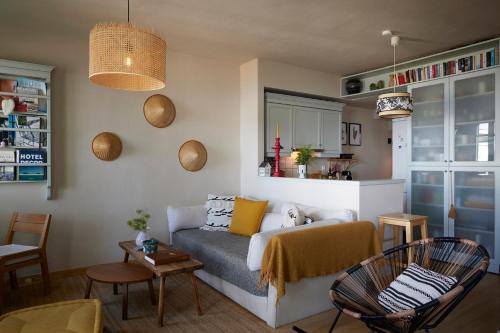 a living room with a couch and a table and chairs at Cycladic Villa ERoza in Ioulida