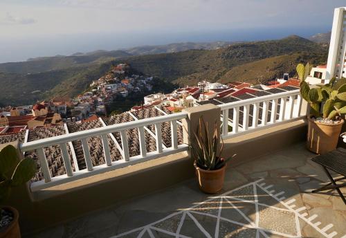 a balcony with a white fence and a view of a city at Cycladic Villa ERoza in Ioulida