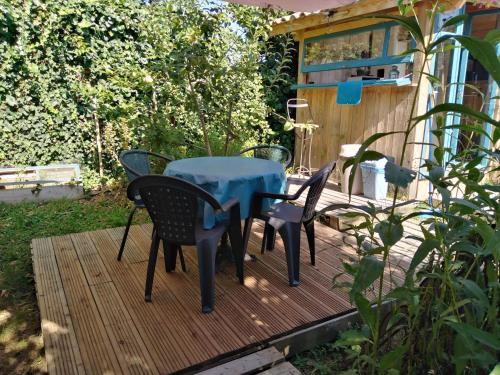 uma mesa azul e cadeiras num deque de madeira em La Yourte du Jardin Caché em Marmande